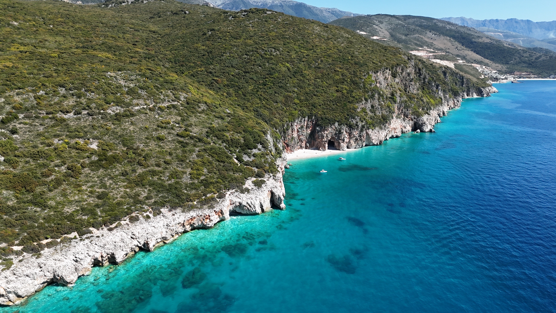 Aerial view of turquoise water and limestone cliffs near Himarë, Albania